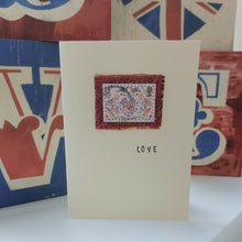 Load image into Gallery viewer, Card with a decorative stamp design and 'LOVE' text, placed against a colorful abstract background.