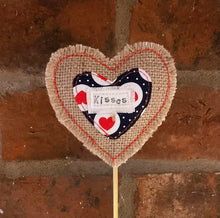 Load image into Gallery viewer, Heart-shaped decorative item with 'Kisses' text against a brick wall background