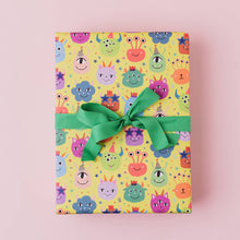 Load image into Gallery viewer, Gift box with colorful monster pattern and green ribbon on a pink background