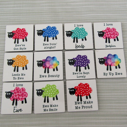 Set of colorful coasters with sheep designs and text on a gray surface