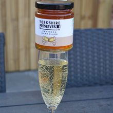 Load image into Gallery viewer, Glass of sparkling wine with a jar of Yorkshire Preserves on a wooden surface

