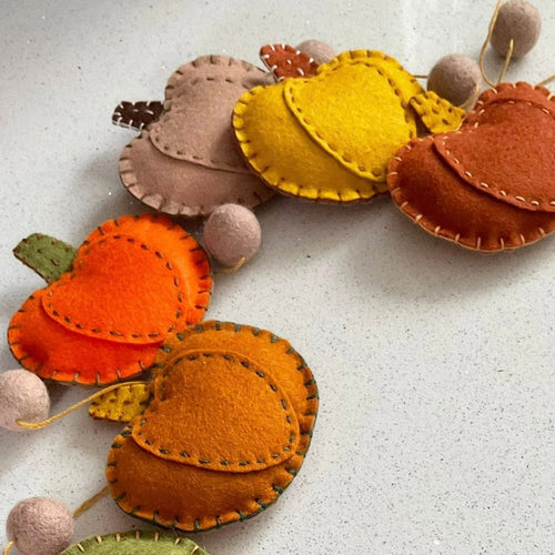 Felt pumpkin garland with colorful pumpkins on a light background