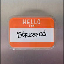 Load image into Gallery viewer, Name tag on a metallic surface with 'HELLO I am Stressed' text
