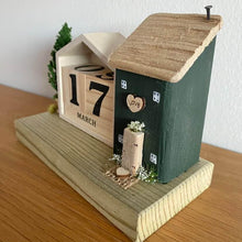 Load image into Gallery viewer, Wooden calendar with decorative elements on a wooden base
