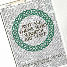 Load image into Gallery viewer, Print with decorative wreath and text &#39;Not all those who wander are lost&#39; on a printed page background.

