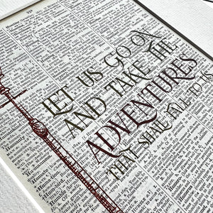 Text on a book page with 'Let us go and take adventures' printed on it.