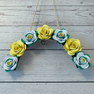 Yorkshire Rose inspired floral arch made of paper flowers on a wooden surface
